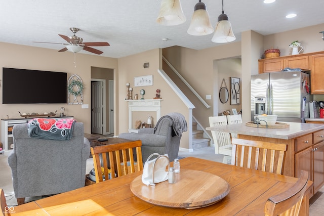 dining room with ceiling fan with notable chandelier and a fireplace