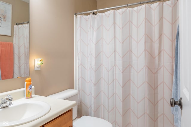 bathroom with a shower with shower curtain, vanity, and toilet