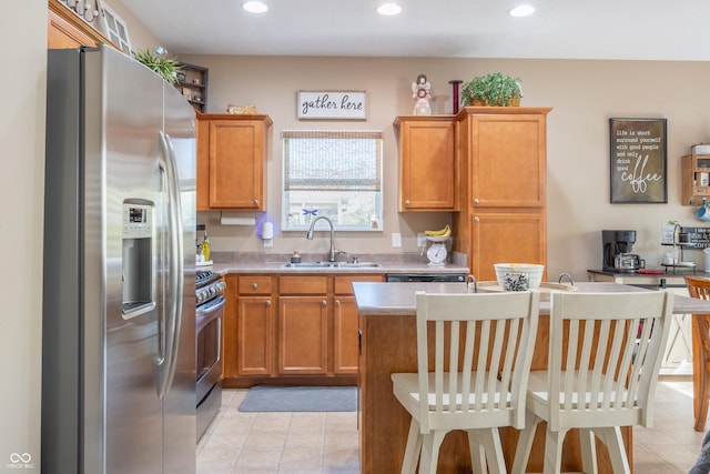 kitchen featuring light tile patterned flooring, appliances with stainless steel finishes, a breakfast bar, sink, and an island with sink