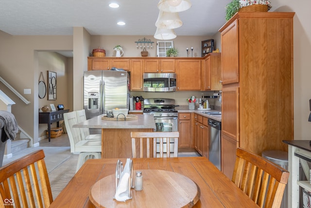 kitchen featuring pendant lighting, a kitchen island, and stainless steel appliances