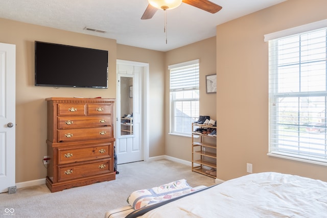 bedroom with ceiling fan and light carpet