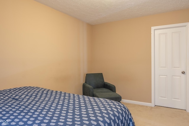 bedroom featuring light colored carpet and a textured ceiling