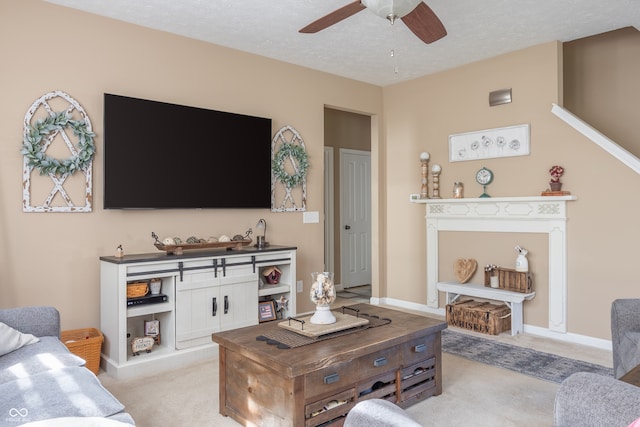 living room featuring light carpet, a textured ceiling, and ceiling fan