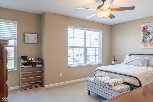 carpeted bedroom with multiple windows and ceiling fan