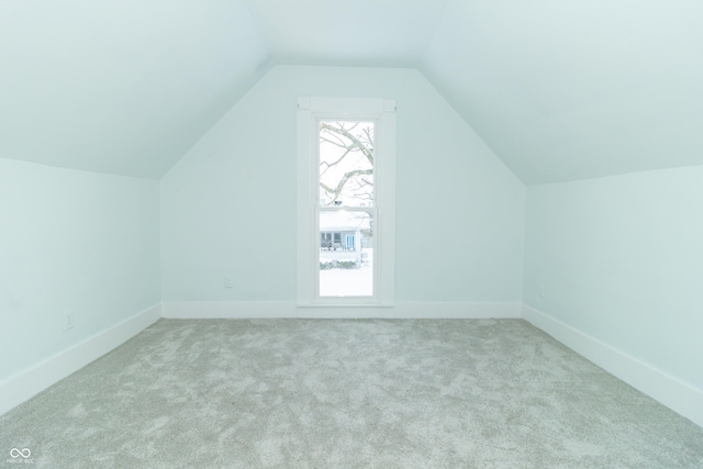 bonus room featuring light colored carpet and vaulted ceiling