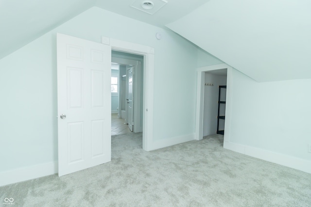 bonus room with light carpet and vaulted ceiling