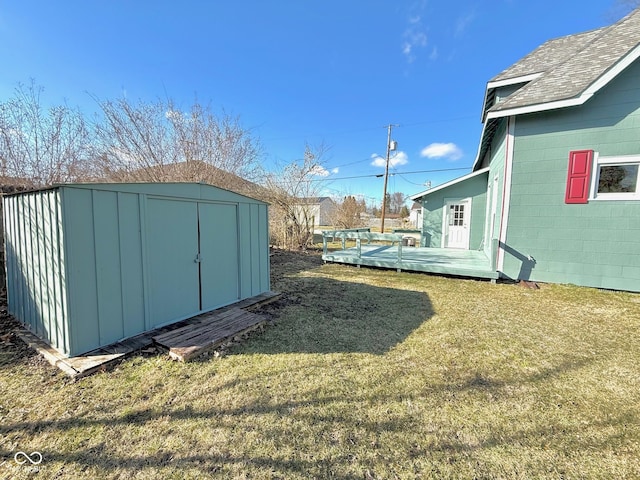 view of yard with an outdoor structure, a wooden deck, and a storage unit