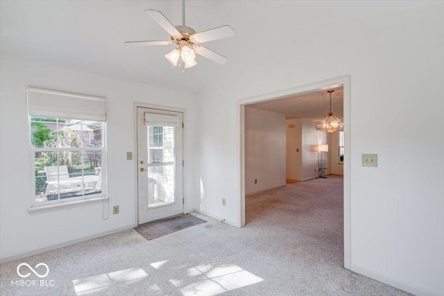 doorway to outside with vaulted ceiling, light carpet, and ceiling fan with notable chandelier