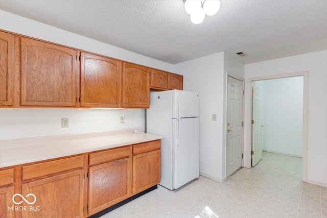 kitchen featuring a textured ceiling and white fridge