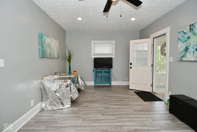 entryway with ceiling fan, a textured ceiling, and hardwood / wood-style flooring