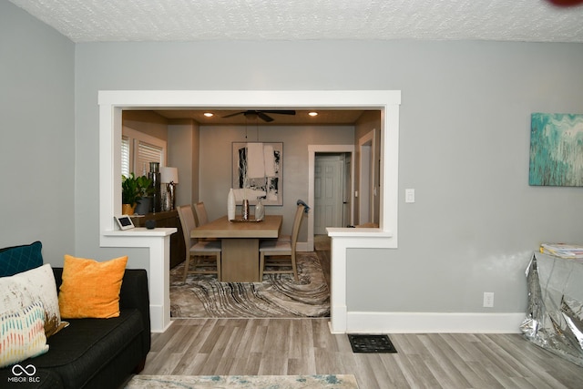 interior space featuring ceiling fan, light hardwood / wood-style floors, and a textured ceiling