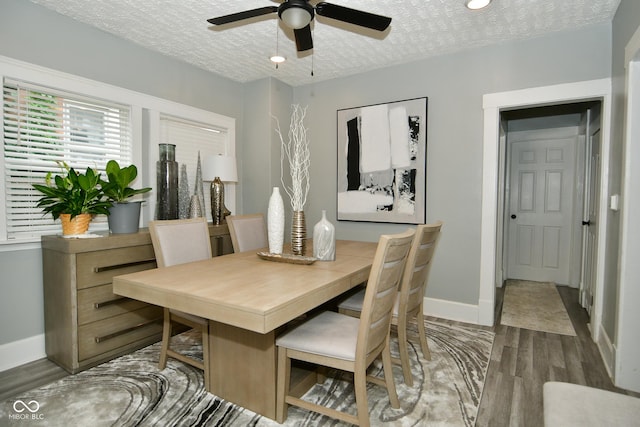 dining room with ceiling fan, dark hardwood / wood-style floors, and a textured ceiling