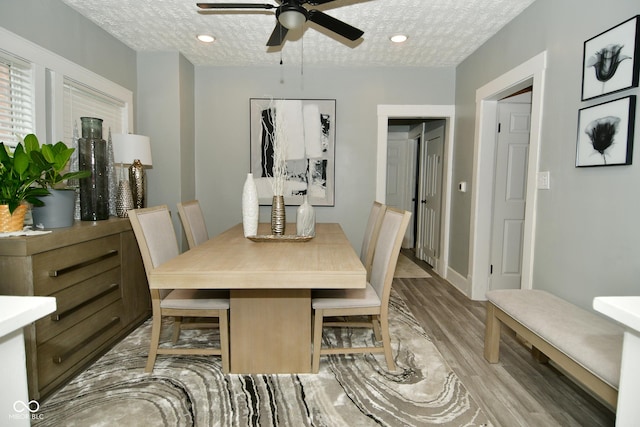 dining area with ceiling fan, light hardwood / wood-style flooring, and a textured ceiling