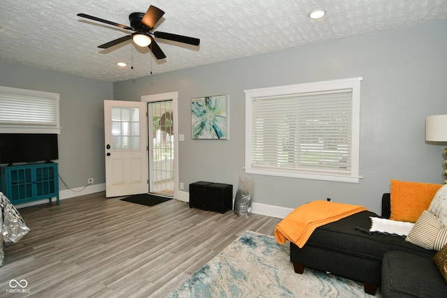 sitting room featuring ceiling fan, hardwood / wood-style floors, and a textured ceiling