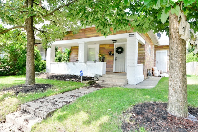 view of front of house with a porch and a front lawn