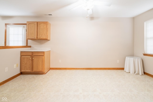 interior space featuring ceiling fan and light brown cabinetry