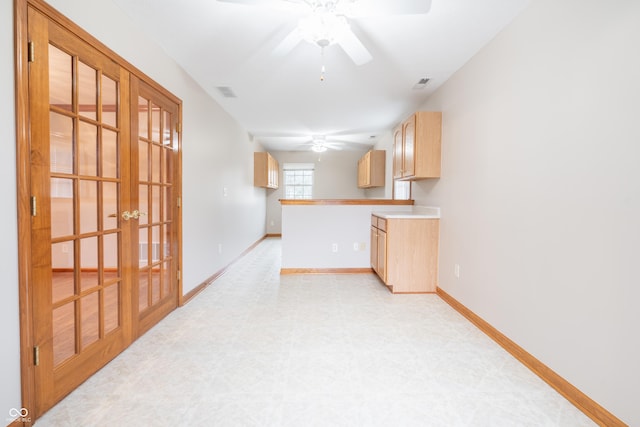 kitchen with kitchen peninsula, light brown cabinetry, ceiling fan, and french doors