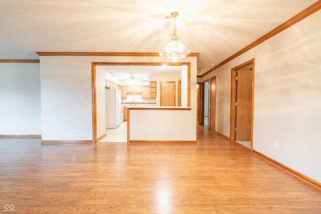 empty room featuring light hardwood / wood-style flooring, a notable chandelier, and ornamental molding