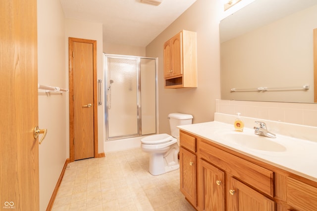 bathroom featuring vanity, toilet, and an enclosed shower