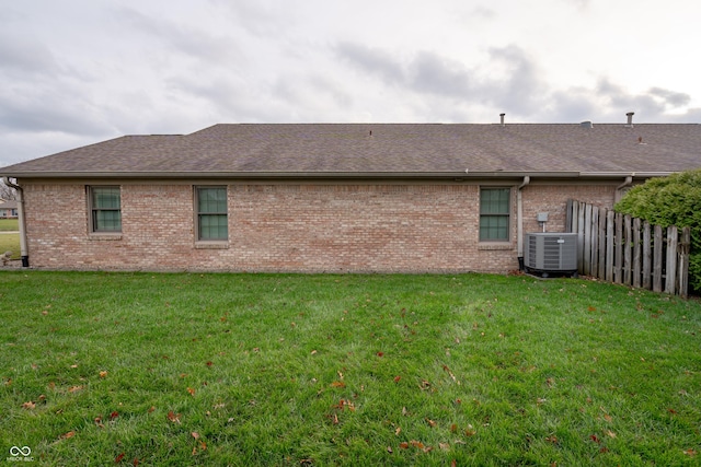 back of house with a lawn and central AC unit