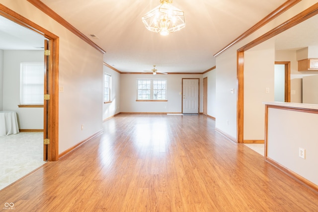 unfurnished room featuring ceiling fan with notable chandelier, ornamental molding, and light hardwood / wood-style flooring