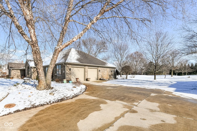 snow covered property with a garage