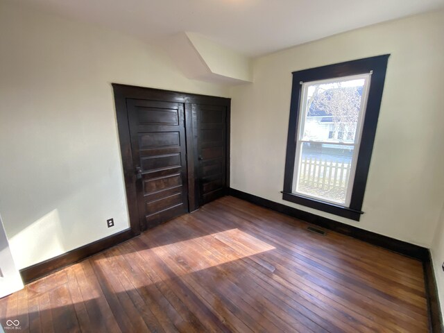 unfurnished bedroom with dark hardwood / wood-style flooring