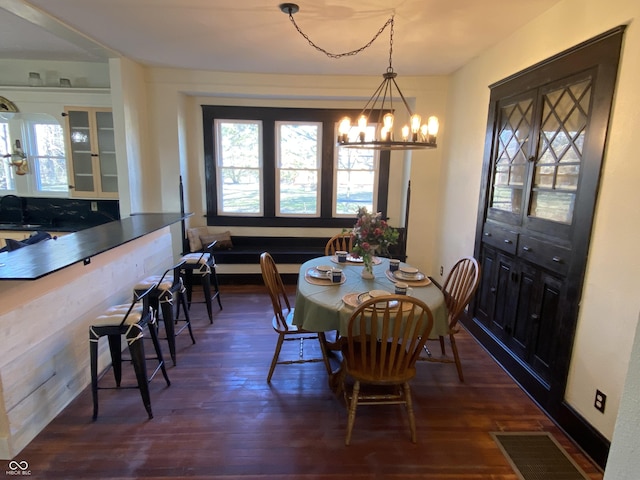 dining area with dark hardwood / wood-style flooring, a notable chandelier, and sink