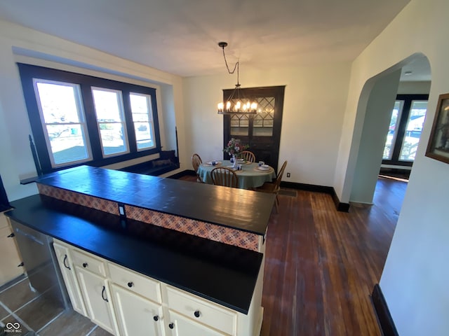 kitchen with white cabinets, pendant lighting, dark hardwood / wood-style floors, and a notable chandelier