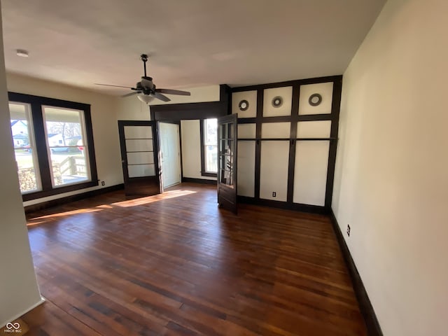 empty room with french doors, dark hardwood / wood-style flooring, and ceiling fan