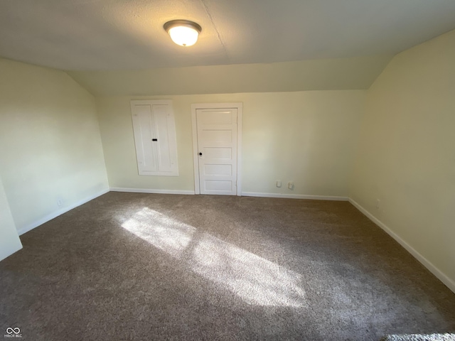 interior space featuring dark carpet and lofted ceiling