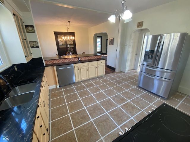 kitchen with stainless steel appliances, sink, pendant lighting, a notable chandelier, and tile patterned flooring