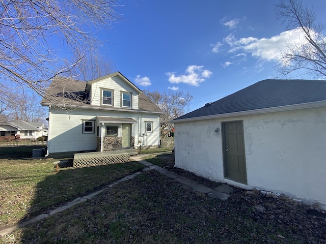 rear view of property with cooling unit and a yard