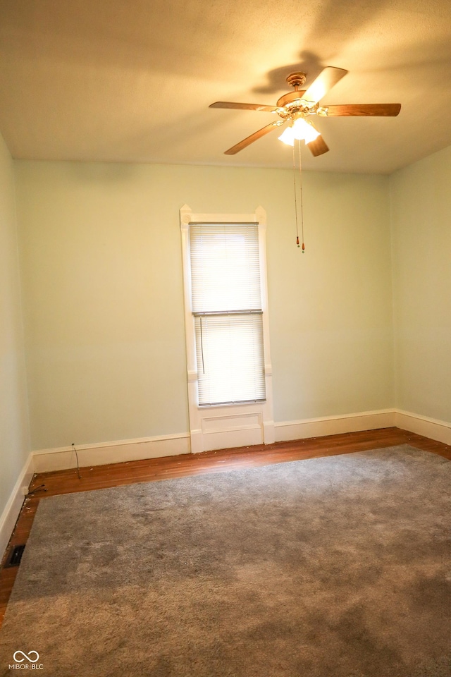 empty room with dark hardwood / wood-style floors and ceiling fan