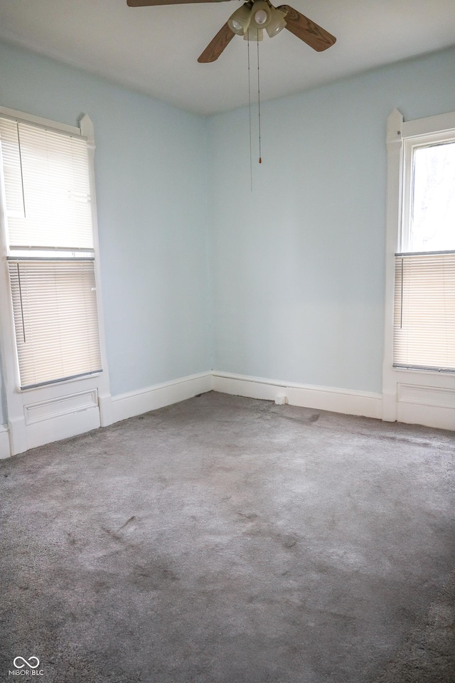 carpeted spare room featuring ceiling fan