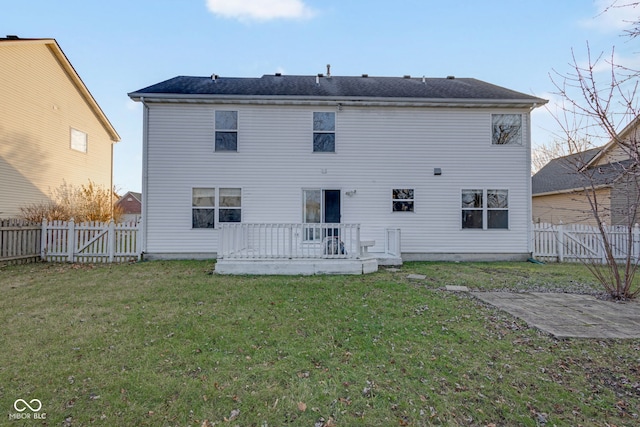 back of property featuring a lawn and a wooden deck