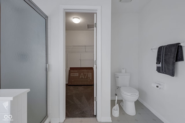 bathroom with an enclosed shower and toilet