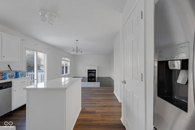 kitchen featuring pendant lighting, white cabinets, a kitchen island, dark hardwood / wood-style flooring, and stainless steel appliances