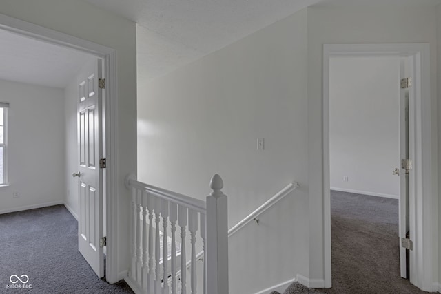 hallway with dark colored carpet