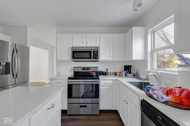 kitchen with white cabinets, dark hardwood / wood-style flooring, stainless steel appliances, and sink