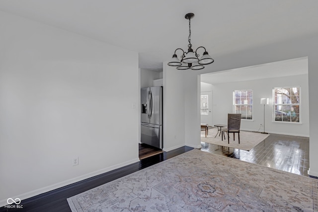 interior space with hanging light fixtures, stainless steel fridge with ice dispenser, dark hardwood / wood-style flooring, a chandelier, and white cabinets