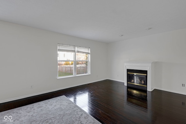 unfurnished living room with dark hardwood / wood-style flooring