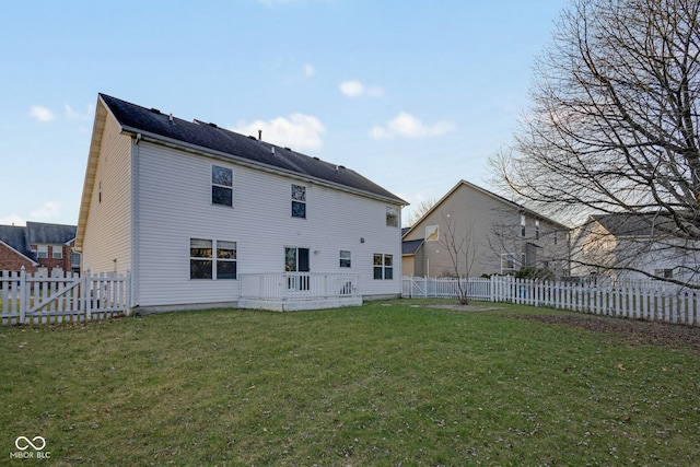 back of property with a lawn and a wooden deck