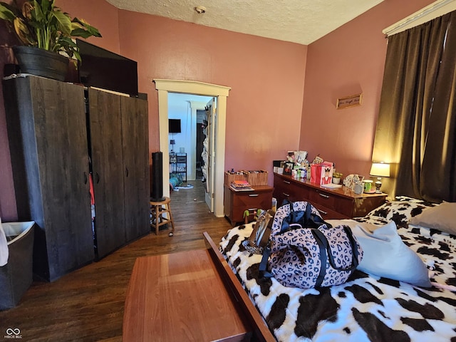 bedroom featuring dark wood-type flooring and a textured ceiling