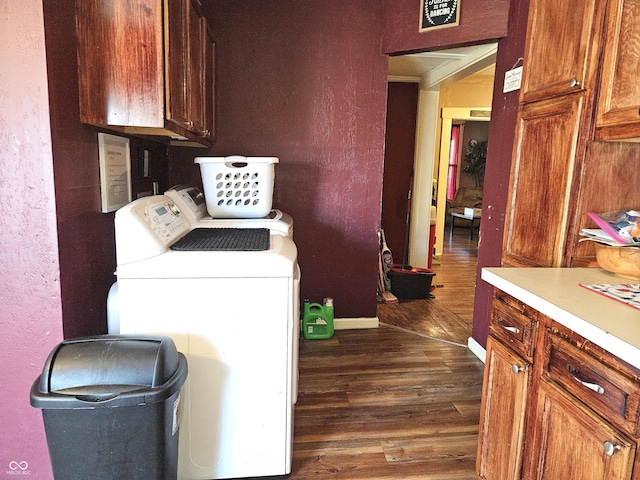 laundry area featuring independent washer and dryer, dark wood-type flooring, and cabinets