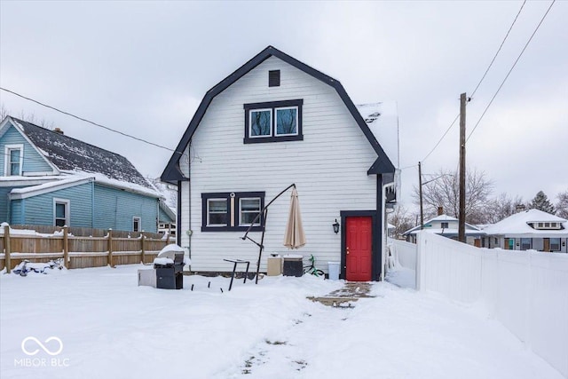 snow covered house featuring central air condition unit