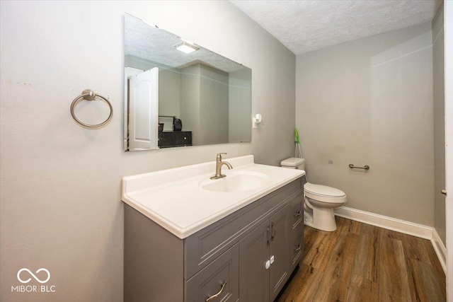 bathroom featuring hardwood / wood-style floors, vanity, a textured ceiling, and toilet