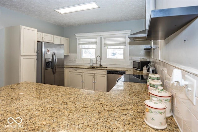 kitchen with appliances with stainless steel finishes, a textured ceiling, white cabinetry, and sink