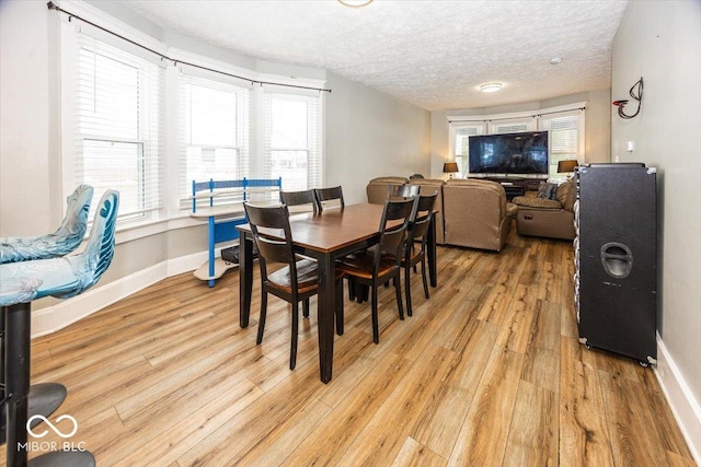 dining space featuring light hardwood / wood-style floors and a textured ceiling