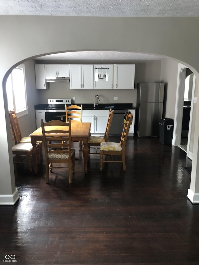 dining area featuring a textured ceiling, dark hardwood / wood-style flooring, and sink